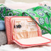 Pink Oabella earring compartment open in a weekender bag