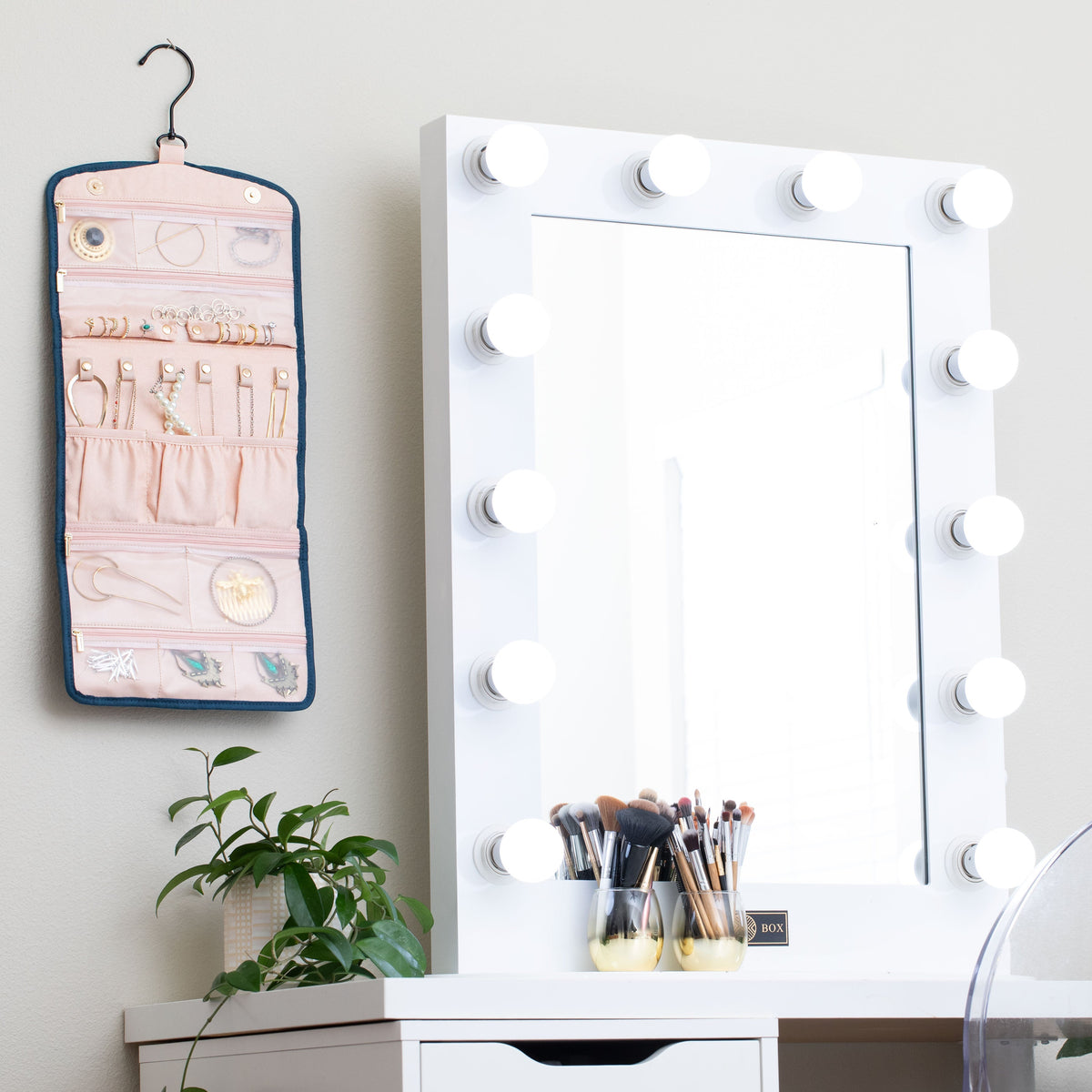 Oabella jewelry organizer hanging next to a vanity mirror